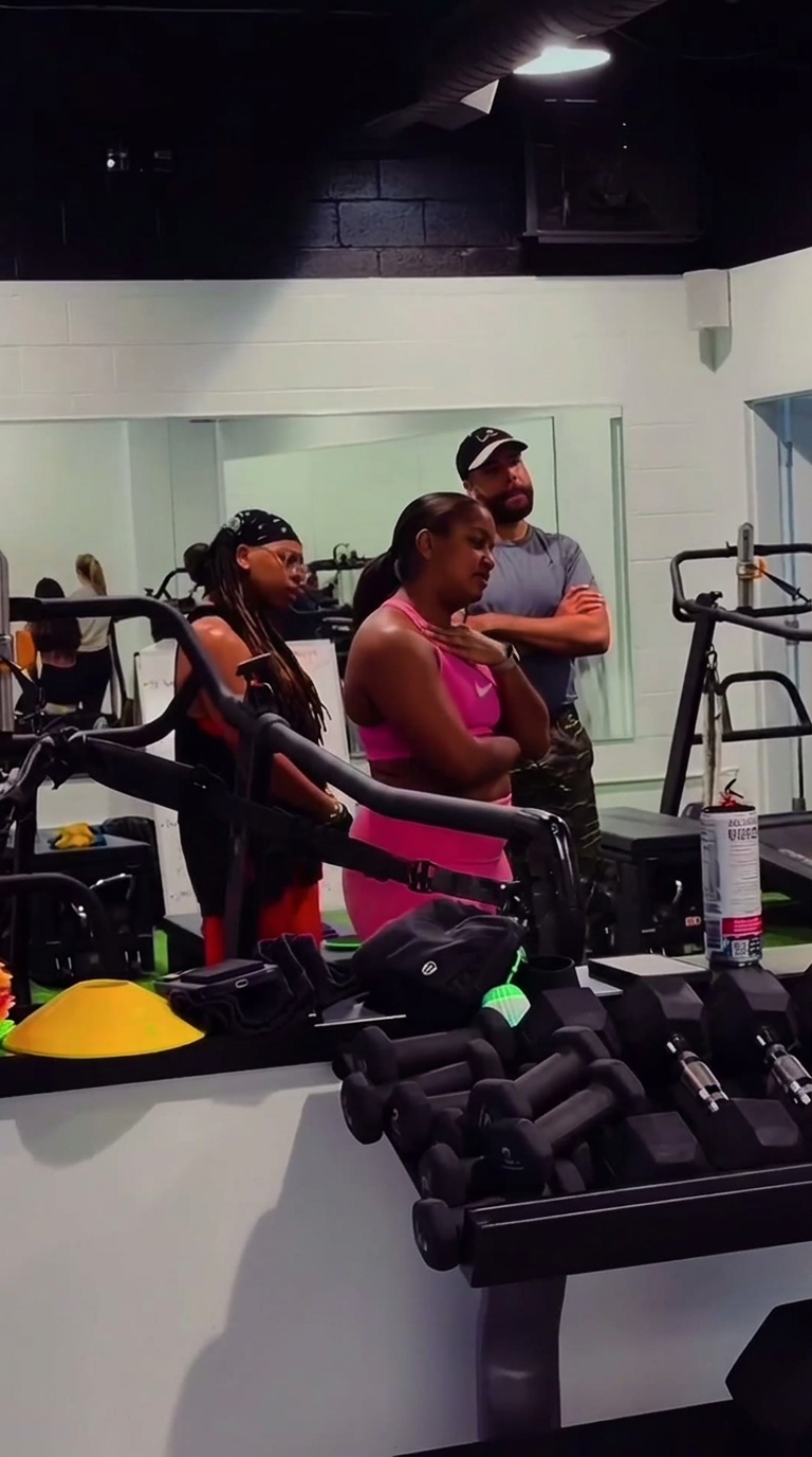 Members talking with a coach by the strength equipment.