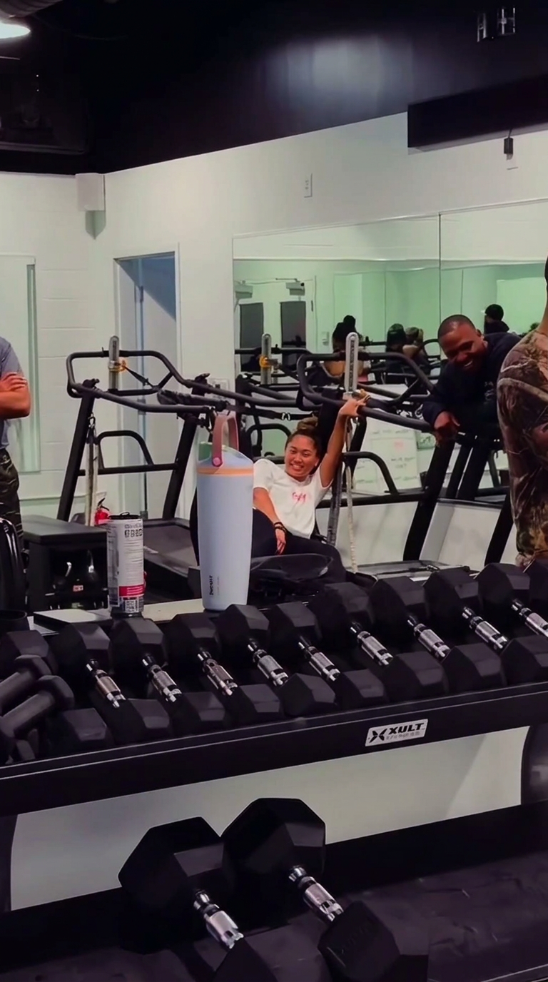 A member smiling between sets while the class gathers around.